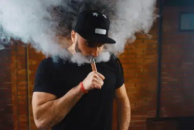 a-man-smoking-vape-wearing-a-cap